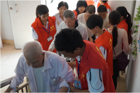 （图五）志愿者们搀扶老人们到会场观看文艺节目