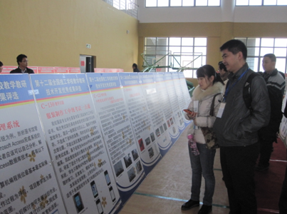 （图二）秦文文、刘宇老师在观看各校参赛作品展板