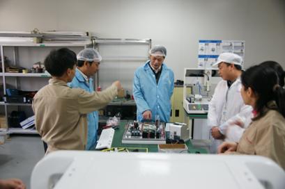 （图二）黎海波校长了解校企共同研发的自动化设备