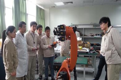 （图一）我校专业教师与企业技术骨干共同学习机器人的操作