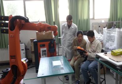 （图一）我校专业教师与企业技术骨干共同学习机器人的操作