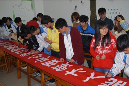 （图一）学生们正在学雷锋标语横幅上签名