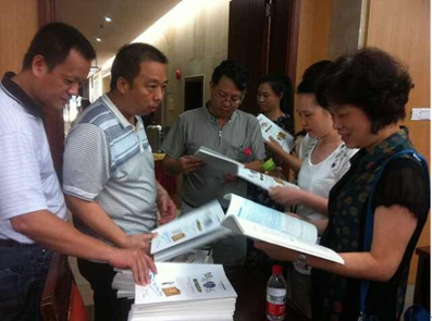 （图二）张海锋副校长向与会人员赠送教材